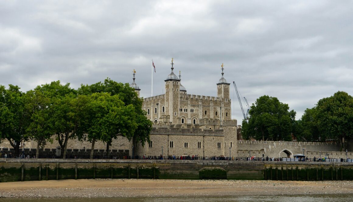 people walking near brown concrete castle under white skies